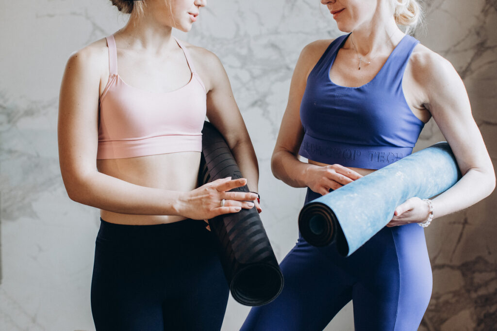 two women with yoga mats